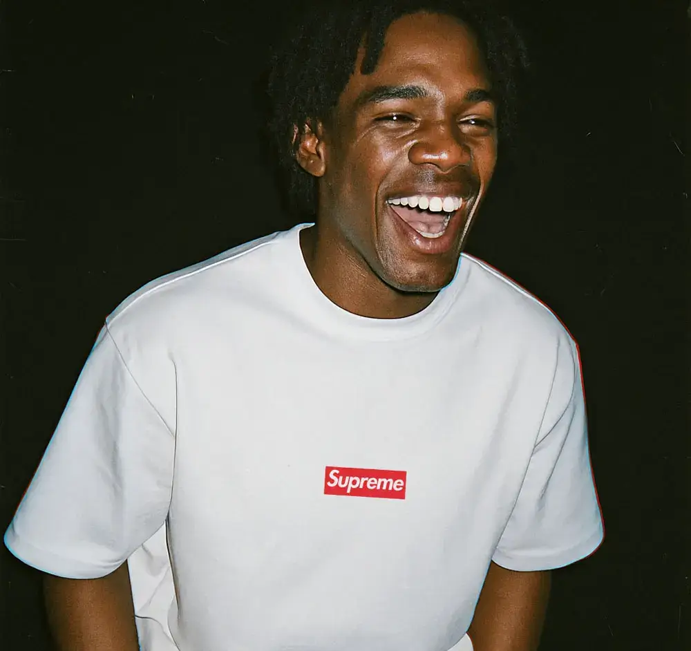 Man smiling, wearing a Supreme t-shirt.